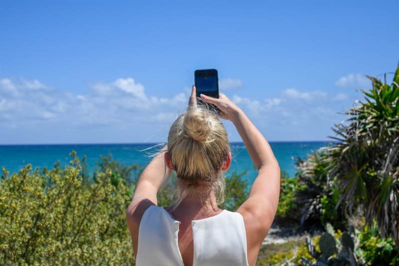 スマートフォンで風景写真を撮影する人のイメージ写真（写真キレイくんのイメージ）